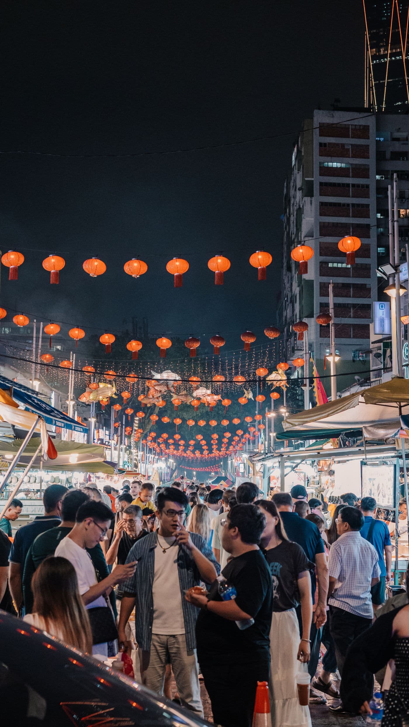 Night market street with hanging red lanterns
