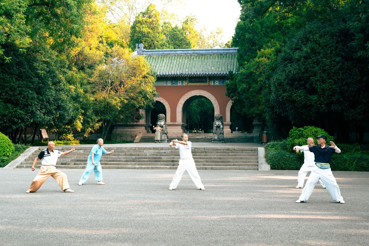 A group practicing tai chi beside a temple